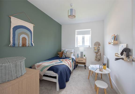 A bedroom with two beds and a rainbow tapestry hanging on the wall.