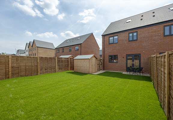 a back garden with a green lawn and brick houses
