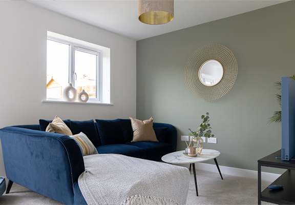 A living room with a blue couch and a white coffee table.