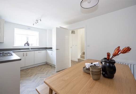 a kitchen with white cabinets and a wooden table