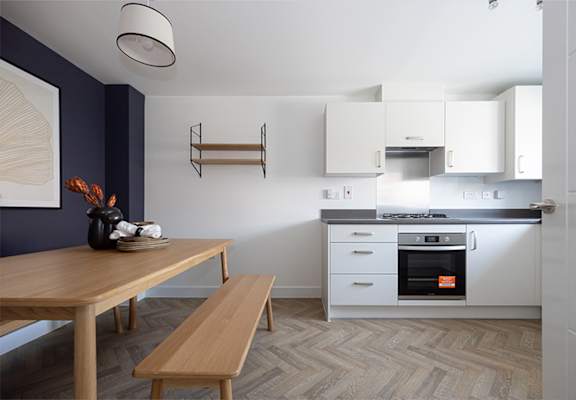 a kitchen with white cabinets and a wooden table