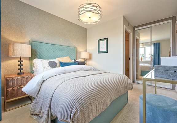 a bedroom with a large bed and a mirrored closet