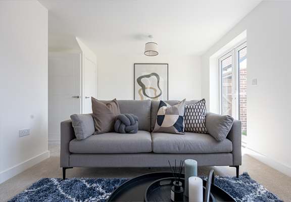 a living room with a grey couch and pillows