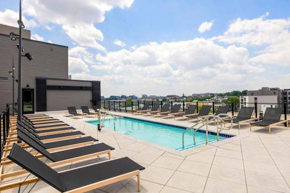 A pool with sun loungers and a building in the background. at Coda at Bryant Street, Washington, DC 20002