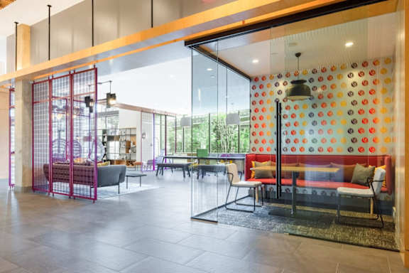 A modern cafe with a glass wall and a red metal gate. at Coda at Bryant Street, Washington, DC 20002