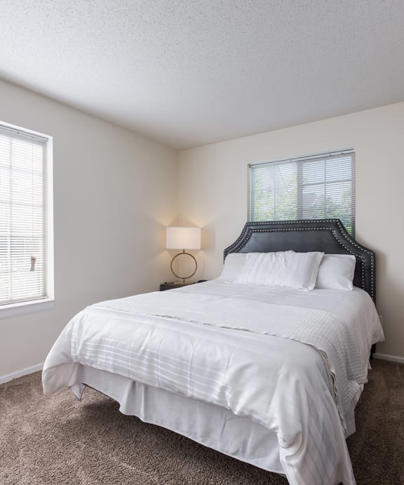 a bedroom with a bed with pillows and two lamps