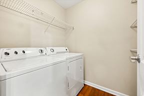 A white dryer and washer in a small laundry room.