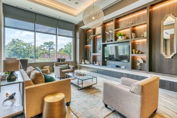 A living room with a large window, a sofa, a coffee table, and a TV.