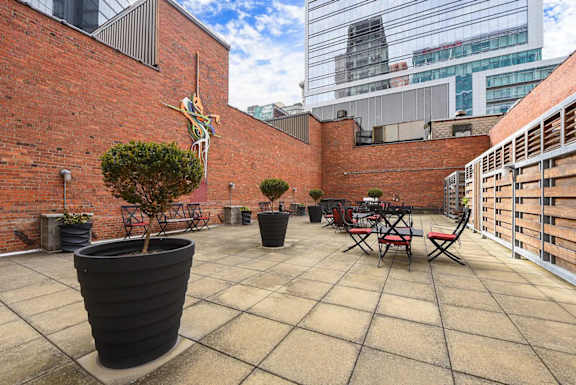 a terrace with tables and chairs and a brick building at Market Square Place, Pittsburgh, PA, 15222