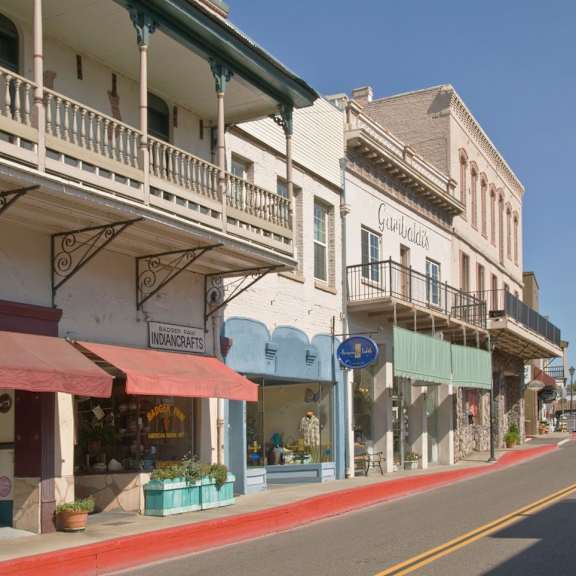 A street view of a row of shops with balconies.