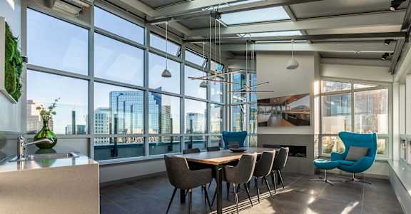 A modern dining room with a table set for six and a view of the city.