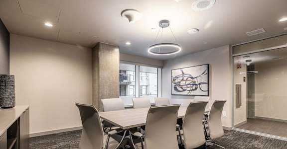 A conference room with a long table and chairs.