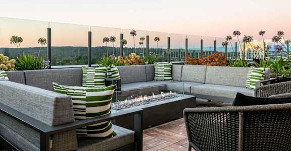 A patio with a fire pit and couches.
