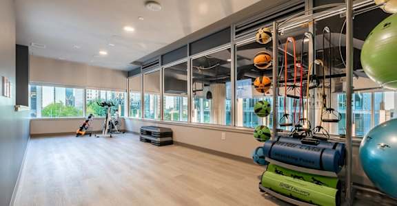 A gym with a variety of equipment including a green exercise ball.