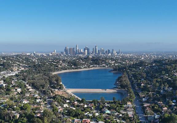 A cityscape with a beach in the foreground and a city skyline in the distance.