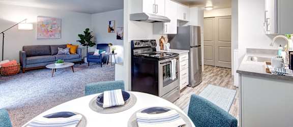 A modern kitchen with a dining table and chairs in the middle of the room.