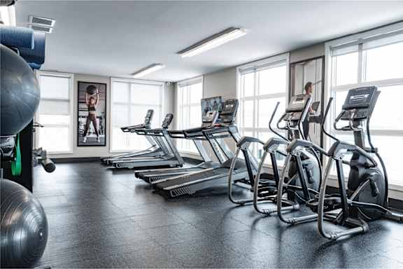 A gym with treadmills and exercise balls.at Podium Apartments, Calgary, AB