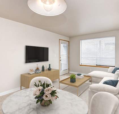 A living room with a white couch, a coffee table, and a flat-screen TV.