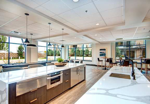 a large kitchen and dining area in a building with large windows