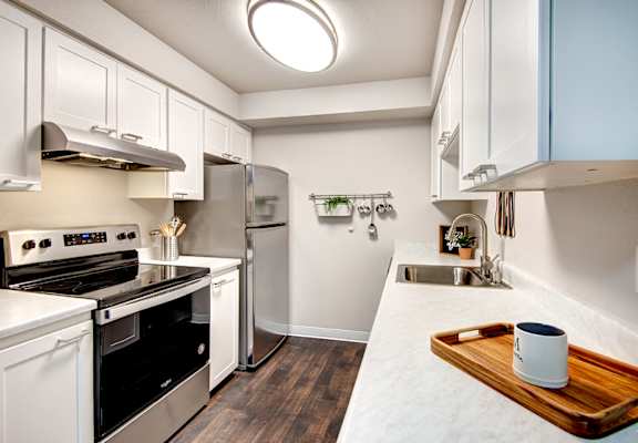 A kitchen with white cabinets and a black stove top oven.