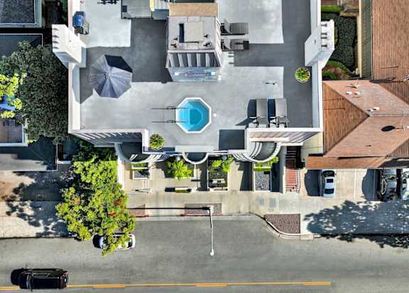 Exterior aerial view of an apartment building with cars parked.