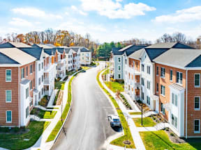 An aerial view of the Hamilton apartment streetscape in Exton, PA showing the lush grass, tree lined street, and on-street parking