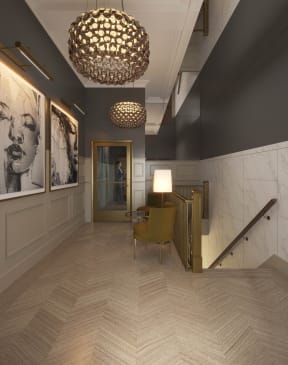a lobby with a chair and a lamp and a staircase at East 4th Street, Cleveland, 44115