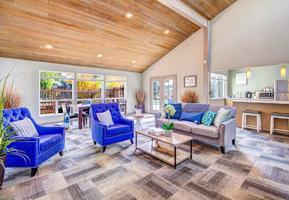 A living room with a blue chair and a grey couch.