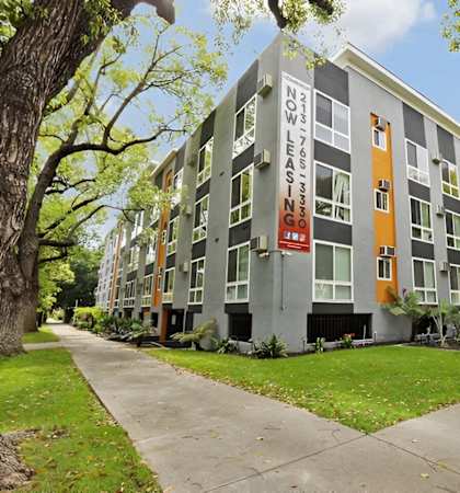 an apartment building with a sidewalk in front of it