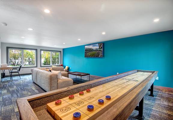 A room with a shiny wooden table and a couch.