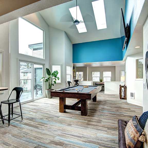 a game room with a pool table and a large window