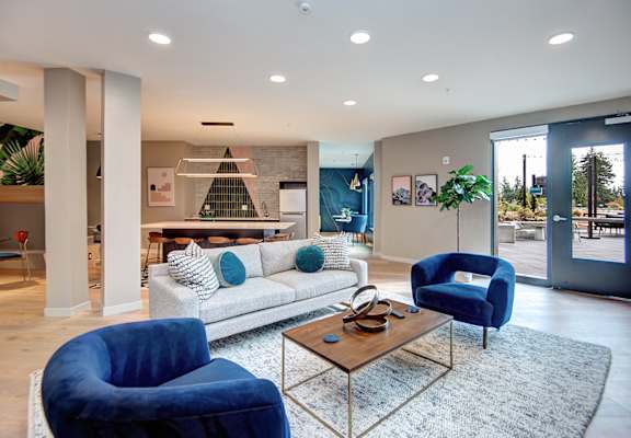 a living room with blue chairs and a couch at Hazel Apartments, Edmonds, 98026
