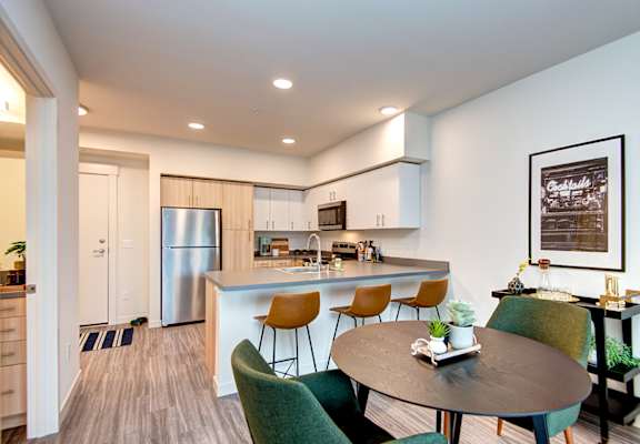 an open kitchen and dining area with a table and chairs at Hazel Apartments, Washington, 98026