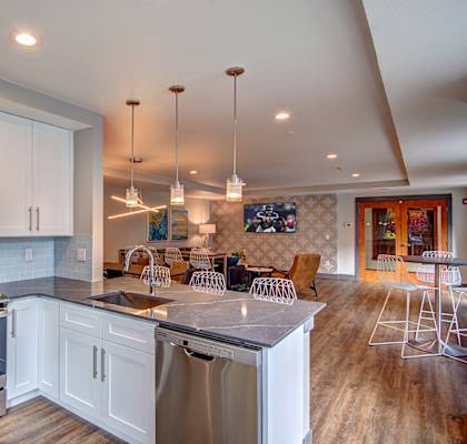 A modern kitchen with white cabinets and stainless steel appliances.
