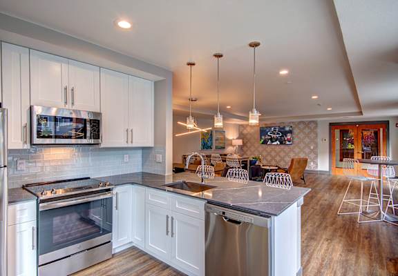 A modern kitchen with white cabinets and stainless steel appliances.