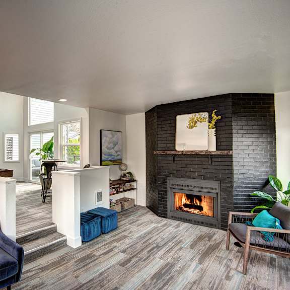 a living room with a fireplace and a kitchen
