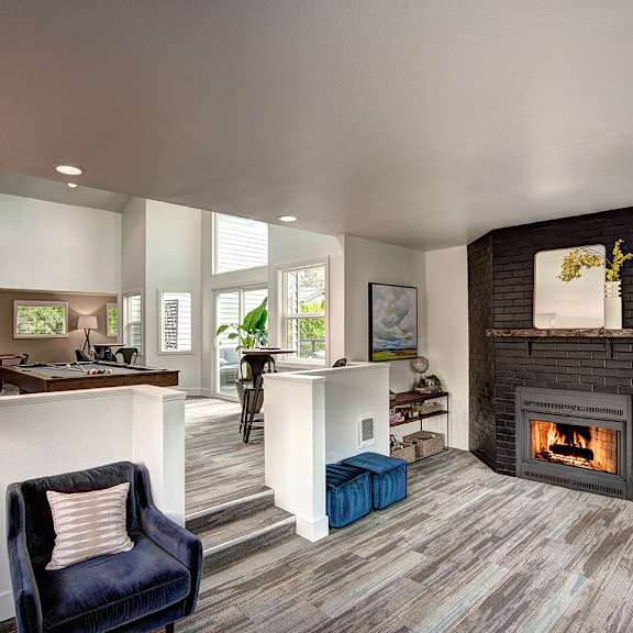a living room with a fireplace and a kitchen