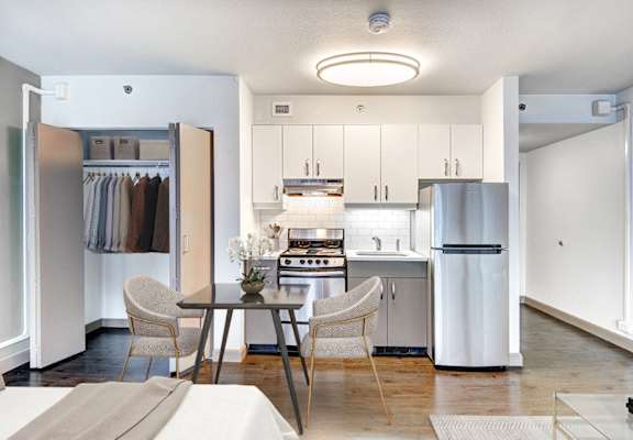 A modern kitchen with a table and chairs in the middle.