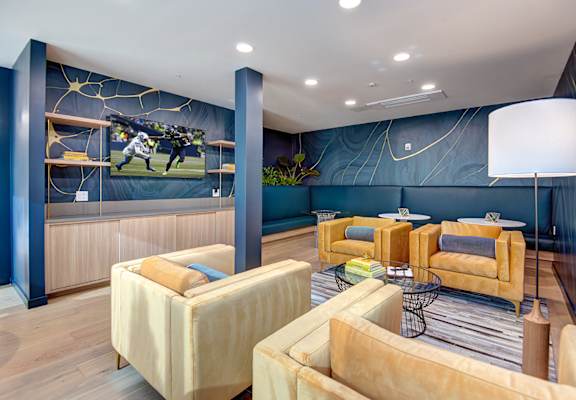 a living room with couches and chairs and a mural on the wall at Hazel Apartments, Edmonds, Washington
