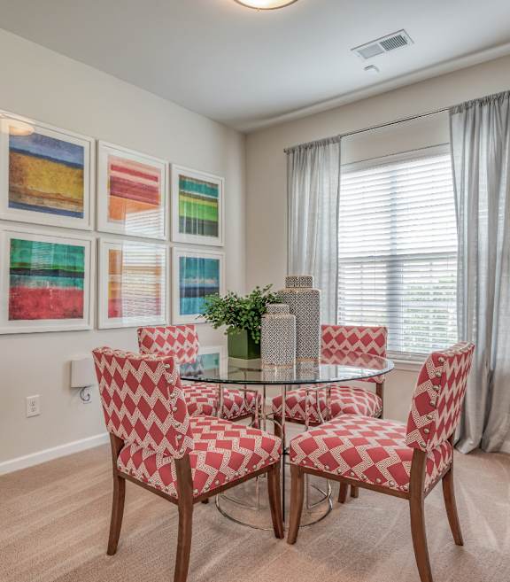 A dining room with a table and chairs.
