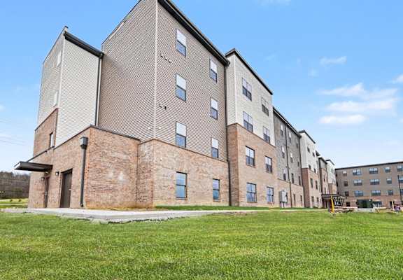 A large multi-story building with a mix of brick and siding exterior.