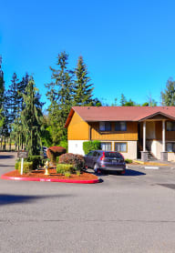 A parking lot with cars and a building in the background. at Autumn Village, Washington, 98354