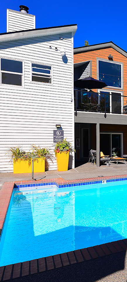 a large swimming pool in front of a clubhouse at Lynx Apartments