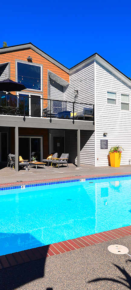 a large swimming pool in front of a clubhouse at Lynx Apartments