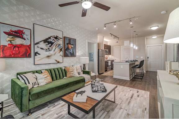 A living room with a green couch and a ceiling fan.