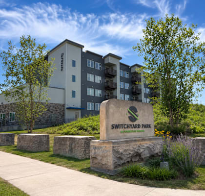 A building with a sign that says Switchyard Park in front of it.