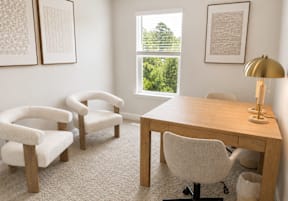A long hallway with a white chair and a plant in the background.