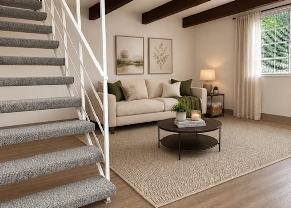 A living room with a staircase, couch, and coffee table.