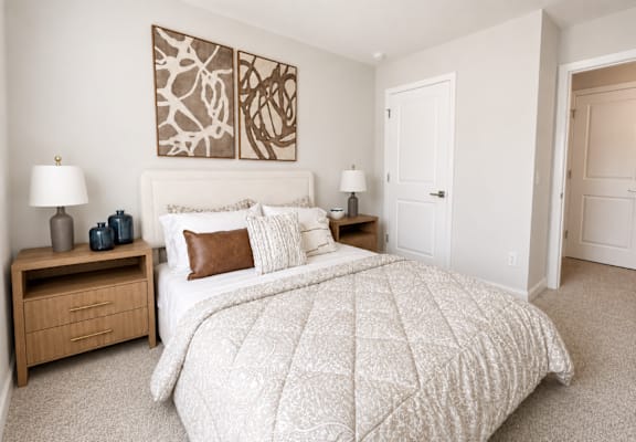 A bedroom with a large bed and two nightstands.