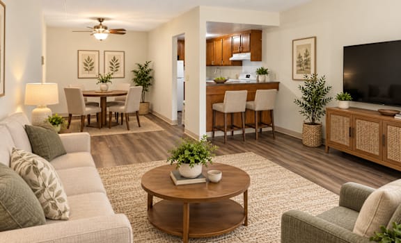 A living room with a grey couch, a wooden coffee table, and a flat screen TV.